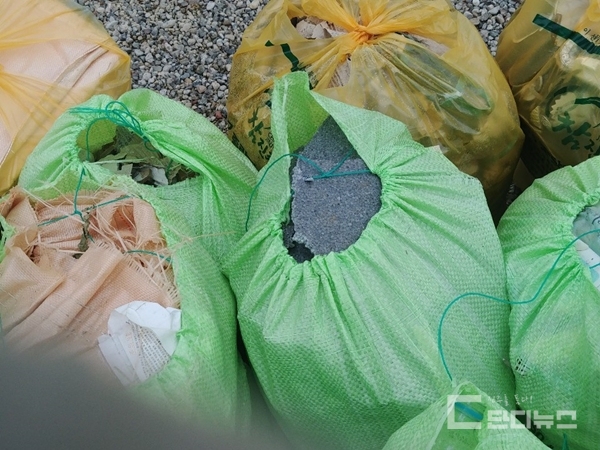 파란색 마대 봉투 안에 건축폐기물이 담겨 있다. [사진 = 단디뉴스DB]