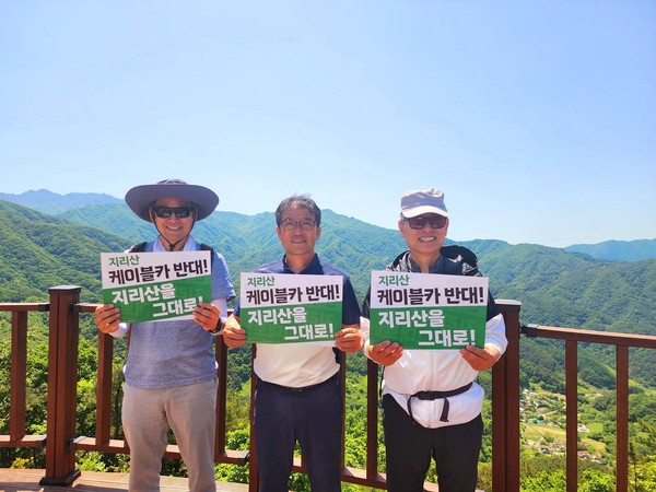 쌍재와 고동재 사이에 있는 전망대에서 저 멀리 천왕봉을 배경으로 ‘지리산 케이블카 반대’ 손팻말을 들다.