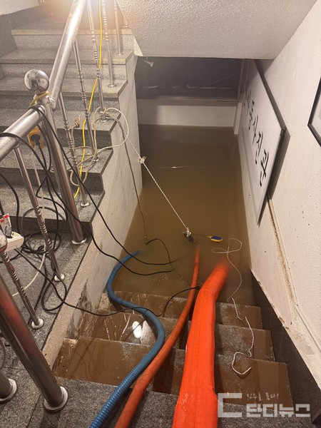 명석삼거리 인근 건물 지하로 물이 차올라 양수기로 빼내고 있는 모습 