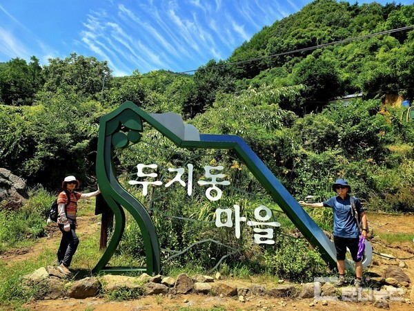 두지동마을 조형물을 배경으로