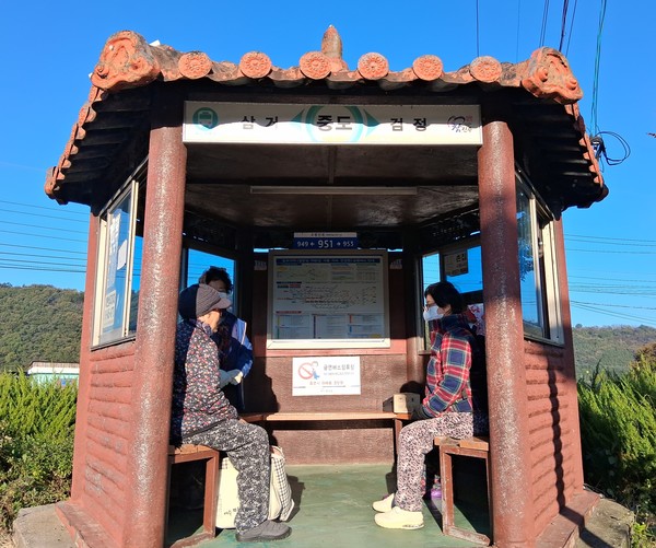 마을 버스 정류장에서 버스를 기다리는 주민들의 모습